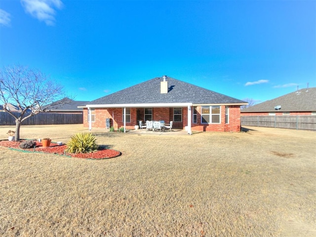 rear view of property with a yard and a patio