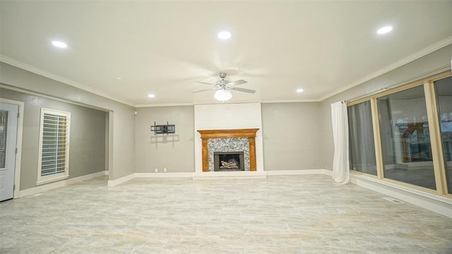 unfurnished living room with a stone fireplace, ceiling fan, and crown molding