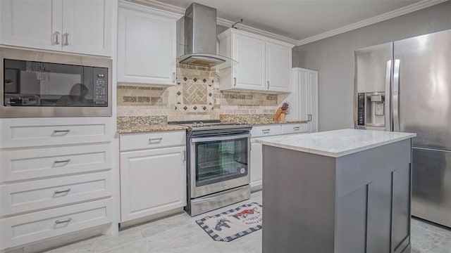 kitchen featuring a kitchen island, wall chimney range hood, white cabinetry, and appliances with stainless steel finishes