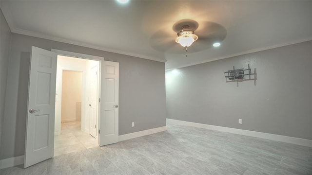 empty room featuring ceiling fan and crown molding