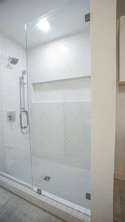 bathroom with tile patterned floors and a shower with shower door