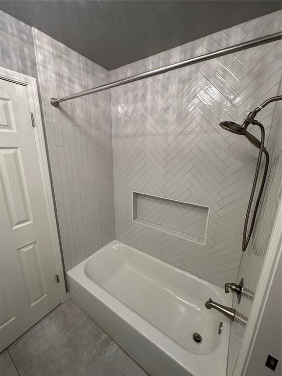 bathroom with tile patterned flooring and tiled shower / bath combo