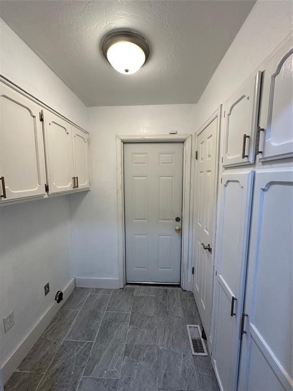 washroom with cabinets and a textured ceiling