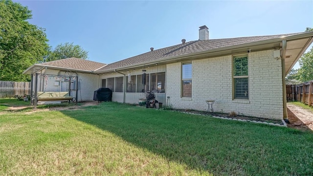 back of house featuring a sunroom and a yard