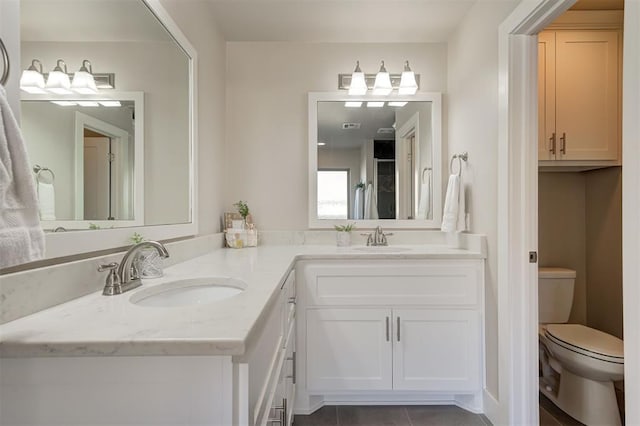 bathroom with vanity, tile patterned floors, and toilet