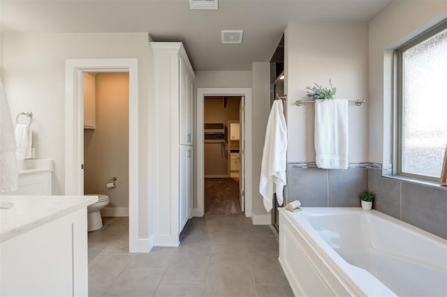 full bathroom with tile patterned flooring, vanity, a wealth of natural light, and toilet