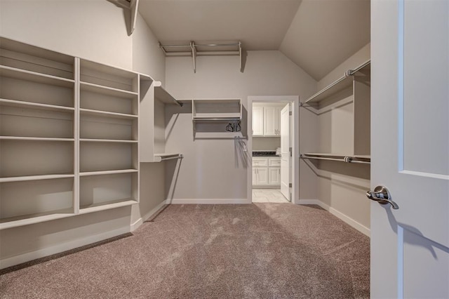 walk in closet featuring lofted ceiling and light carpet