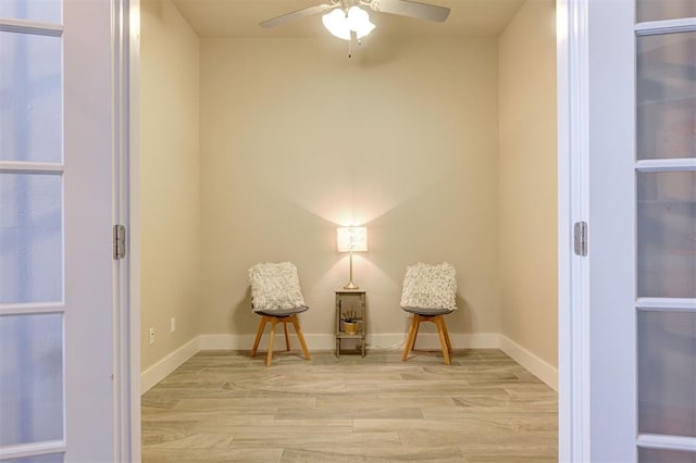 sitting room with ceiling fan and light wood-type flooring