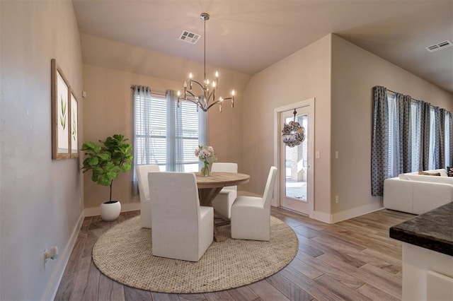 dining area with a chandelier and light hardwood / wood-style flooring