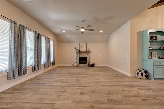 unfurnished living room featuring lofted ceiling, a fireplace, ceiling fan, and light hardwood / wood-style flooring