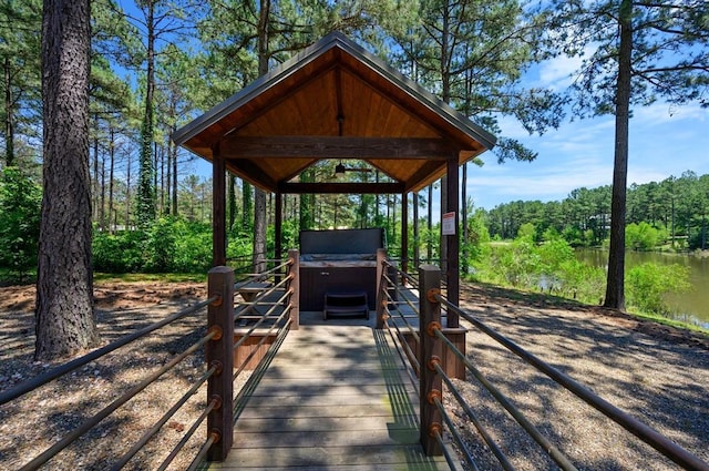 exterior space with a gazebo, a water view, and a hot tub