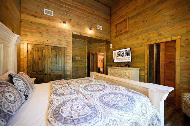 bedroom featuring wooden walls and a towering ceiling