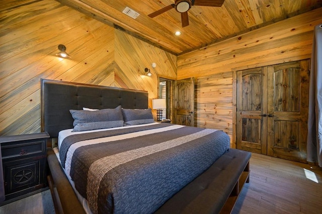 bedroom featuring wood-type flooring, ceiling fan, wood walls, and wood ceiling