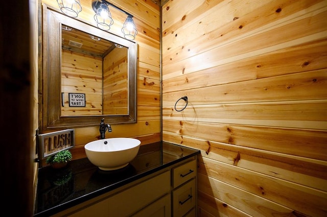 bathroom with vanity and wood walls