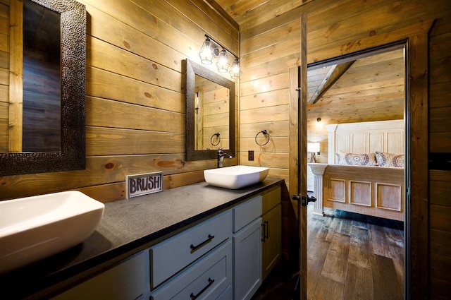 bathroom featuring wooden walls, hardwood / wood-style floors, vanity, and wood ceiling