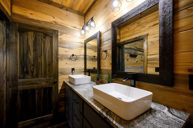 bathroom with wood walls, vanity, and wooden ceiling