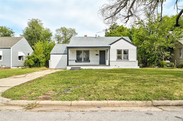 view of front of home with covered porch and a front lawn