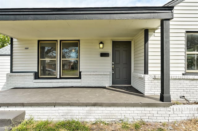 view of exterior entry with a porch