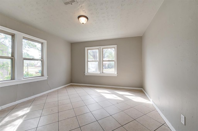 tiled spare room with a textured ceiling