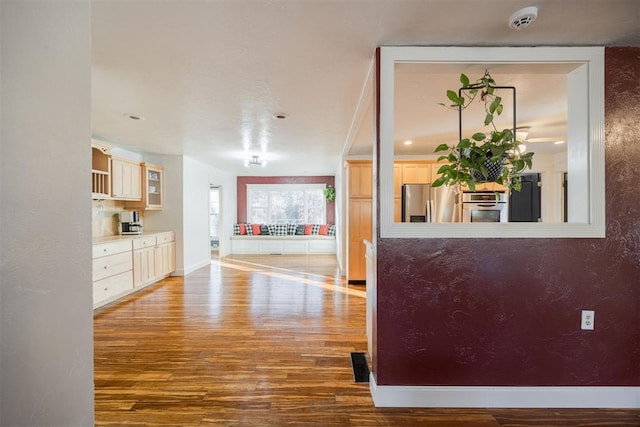 interior space with stainless steel fridge with ice dispenser and hardwood / wood-style flooring