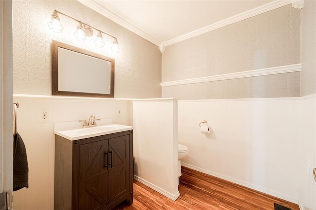 bathroom featuring vanity, hardwood / wood-style flooring, crown molding, and toilet