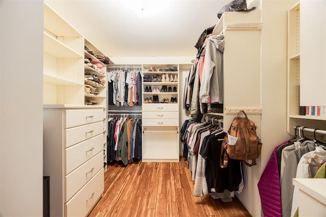 walk in closet with light hardwood / wood-style floors