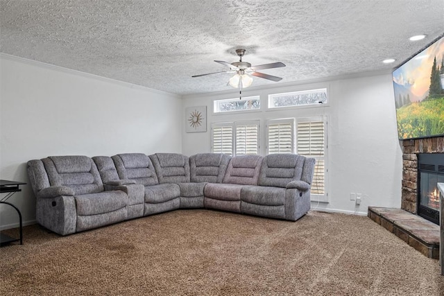 living room with carpet, a stone fireplace, ornamental molding, and a textured ceiling