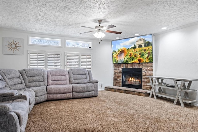 living room with ceiling fan, a stone fireplace, carpet floors, and a textured ceiling