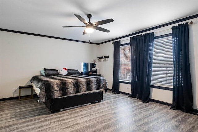 bedroom featuring ceiling fan, hardwood / wood-style floors, and crown molding