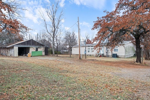 view of yard with central air condition unit and an outbuilding