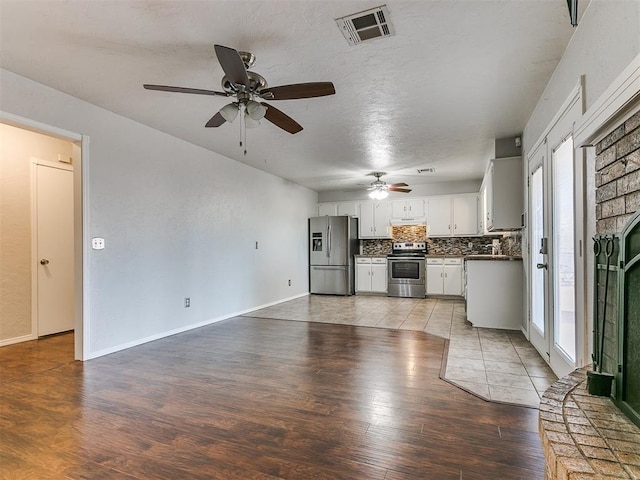 unfurnished living room featuring ceiling fan, light hardwood / wood-style flooring, and a brick fireplace