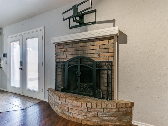 room details with a fireplace, wood-type flooring, and french doors