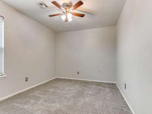 empty room with carpet, ceiling fan, and a textured ceiling