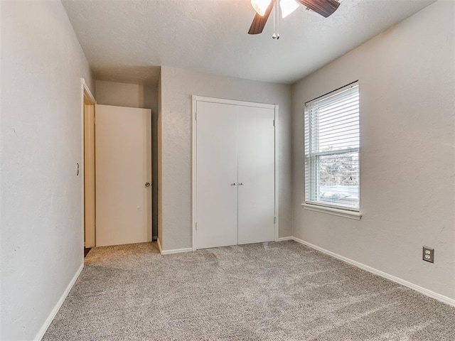 unfurnished bedroom with a closet, ceiling fan, and light colored carpet