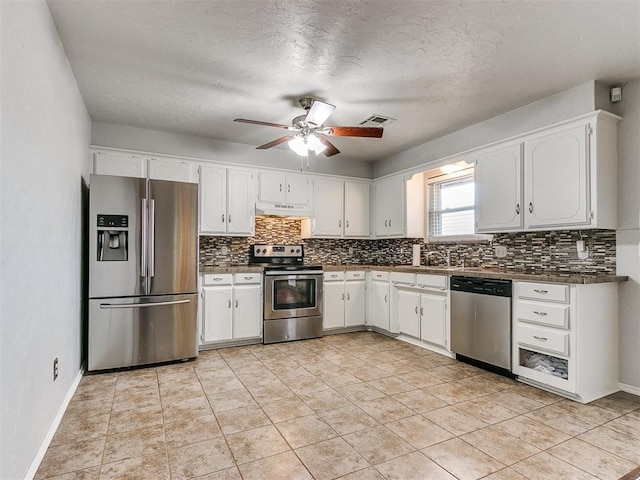 kitchen with appliances with stainless steel finishes, a textured ceiling, ceiling fan, light tile patterned floors, and white cabinetry