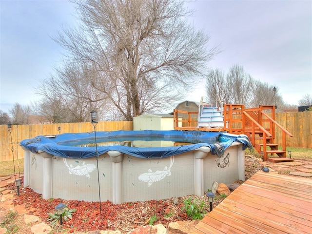 view of pool featuring a wooden deck and a storage shed