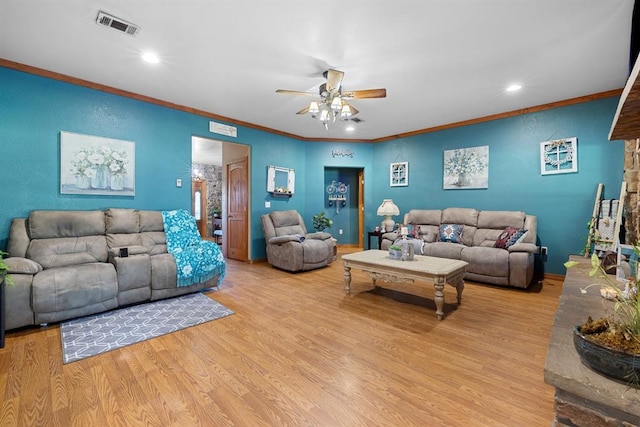 living room with crown molding, ceiling fan, and light wood-type flooring