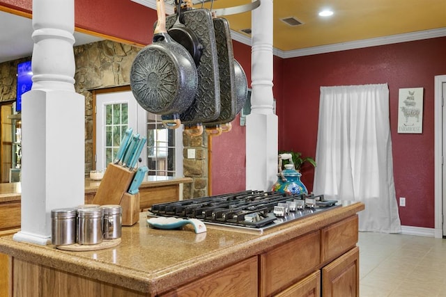 kitchen featuring ornamental molding, stainless steel gas stovetop, and ornate columns