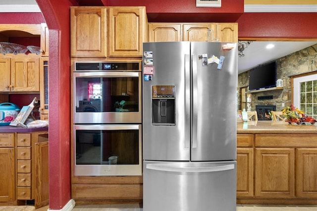 kitchen featuring a fireplace and appliances with stainless steel finishes