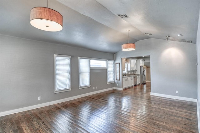 unfurnished living room featuring dark hardwood / wood-style floors, lofted ceiling, and sink