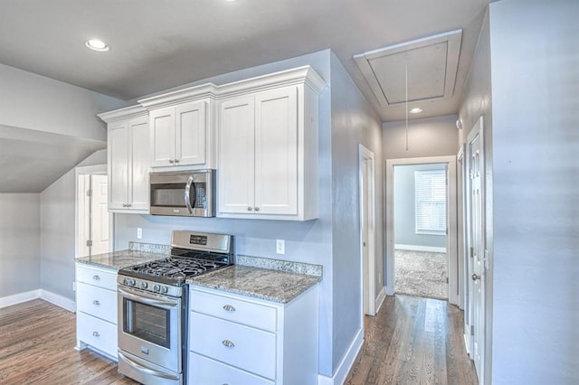 kitchen featuring light stone countertops, white cabinets, stainless steel appliances, and hardwood / wood-style flooring