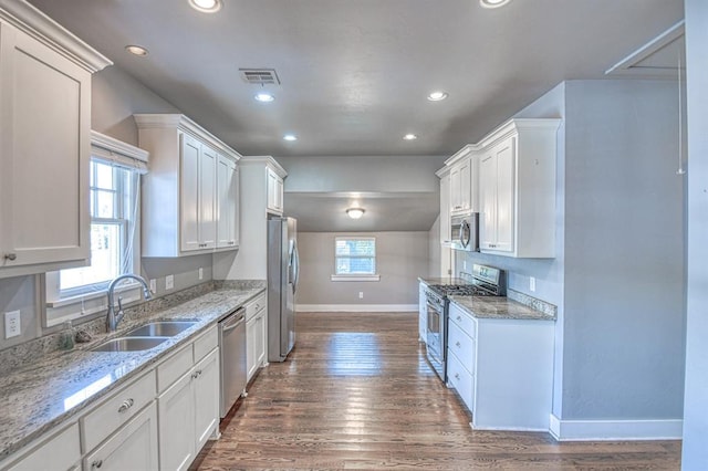 kitchen featuring light stone countertops, sink, dark hardwood / wood-style flooring, white cabinets, and appliances with stainless steel finishes