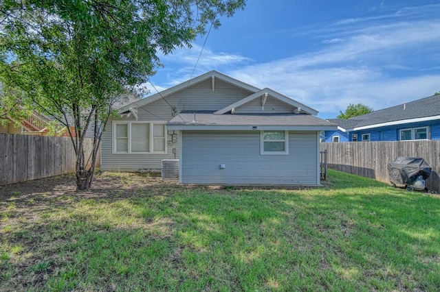 rear view of property with a lawn and central AC unit