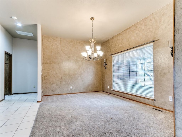 tiled spare room with a notable chandelier