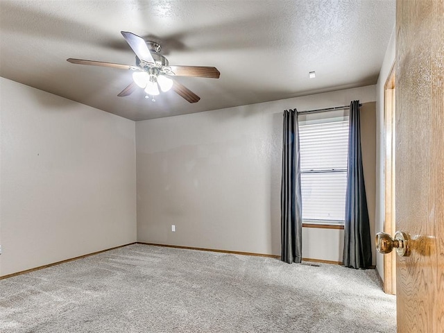 unfurnished room featuring a textured ceiling, ceiling fan, and light carpet