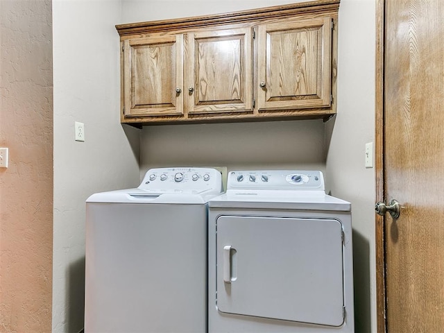 washroom with washing machine and dryer and cabinets