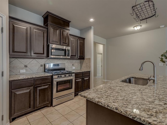 kitchen featuring decorative backsplash, appliances with stainless steel finishes, dark brown cabinets, and sink