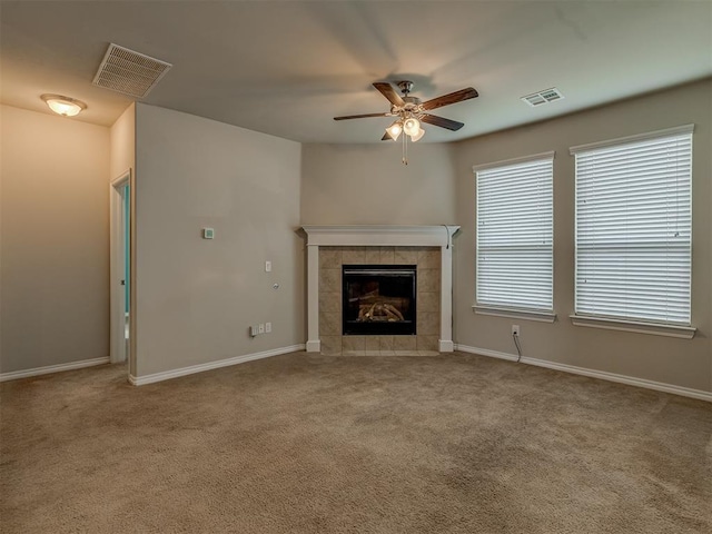 unfurnished living room featuring ceiling fan, light colored carpet, and a fireplace