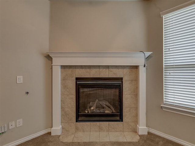 interior details with carpet floors and a tiled fireplace