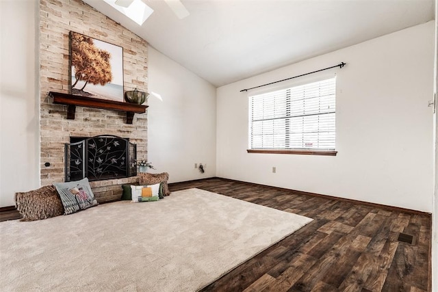 living room with dark wood-type flooring, a fireplace, and vaulted ceiling